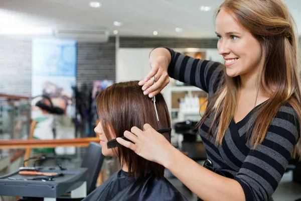 Cabeleireiro dando um corte de cabelo para a mulher — Fotografia de Stock