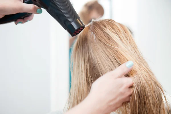 Stylist torkning kvinnans hår — Stockfoto