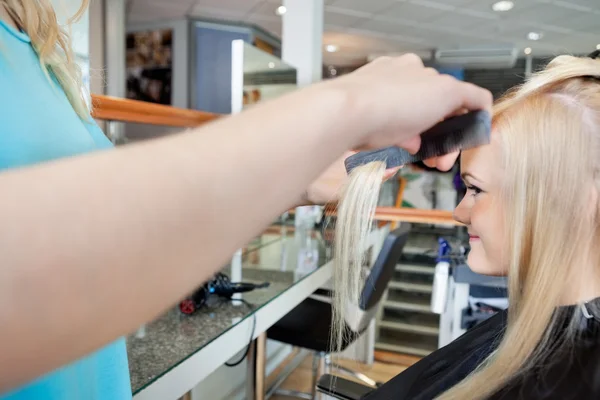 Česání vlasů kadeřnice ženy — Stock fotografie