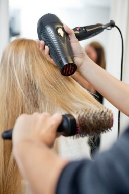 stilist Kuaför salon kadının saç kurutma