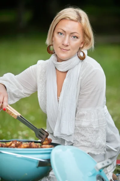 Žena připravuje jídlo na grilu — Stock fotografie