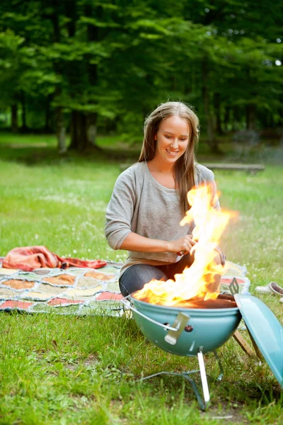 Vrouwelijke voorbereiding van de maaltijd op vlammende barbecue — Stockfoto