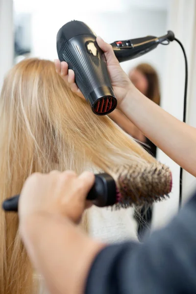 Стилист Сушка волос женщины в парикмахерской — стоковое фото