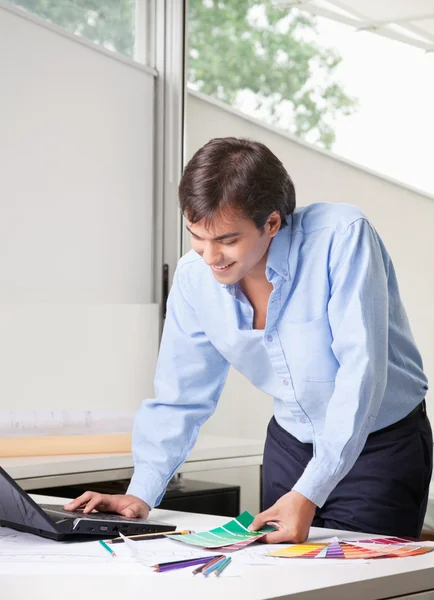 Designer de interiores masculino usando laptop — Fotografia de Stock