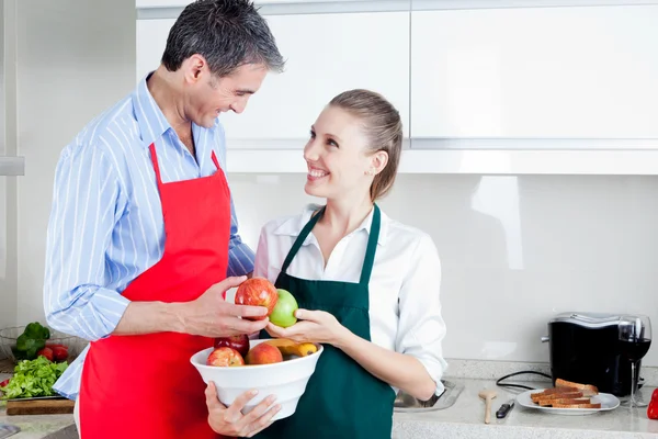 Lyckliga par i köket förbereder mat — Stockfoto