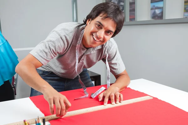 Happy Dressmaker Measuring Red Fabric — Stock Photo, Image