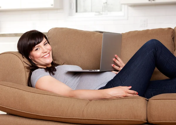 Расслабленная беременная женщина с компьютером — стоковое фото
