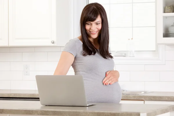Беременная женщина с ноутбуком — стоковое фото