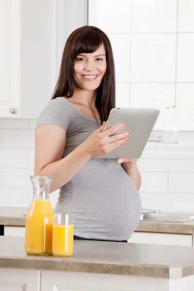 Беременная женщина на кухне — стоковое фото