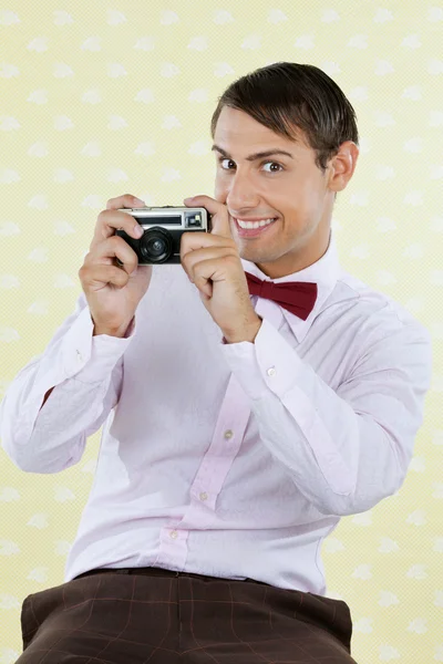 Masculino geek segurando retro câmera — Fotografia de Stock