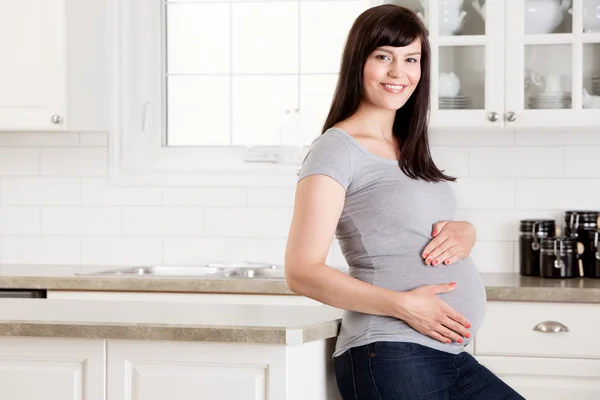Беременная женщина с руками на животе — стоковое фото
