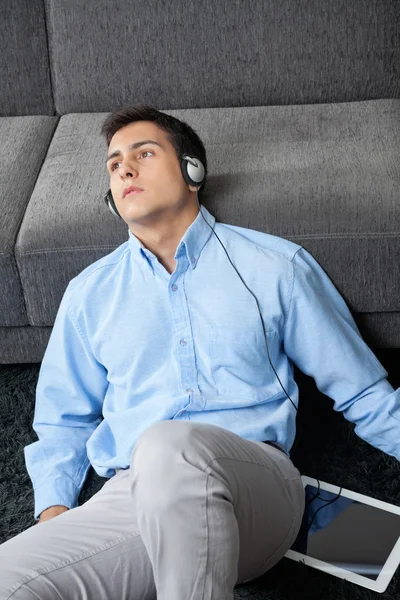 Człowiek słuchania muzyki na cyfrowy tablicowy — Zdjęcie stockowe