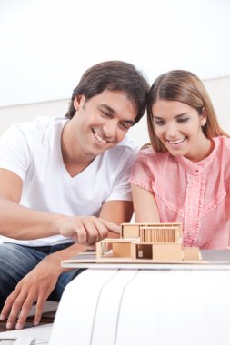 Couple Looking at House Model clipart