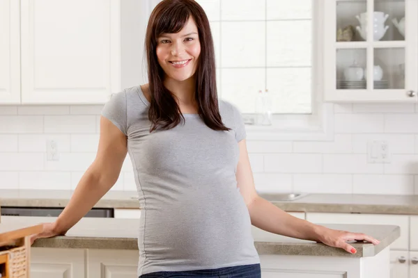 Šťastné těhotná žena v domácnosti — Stock fotografie