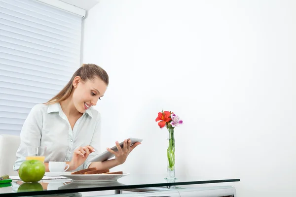 Geschäftsfrau am Frühstückstisch mit Tablet-PC — Stockfoto