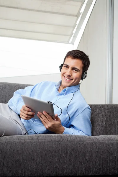 Homem ouvindo música no tablet digital — Fotografia de Stock