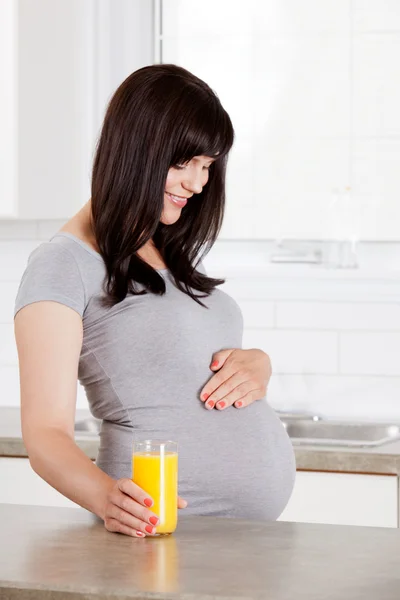 Mulher grávida olhando para baixo na barriga — Fotografia de Stock