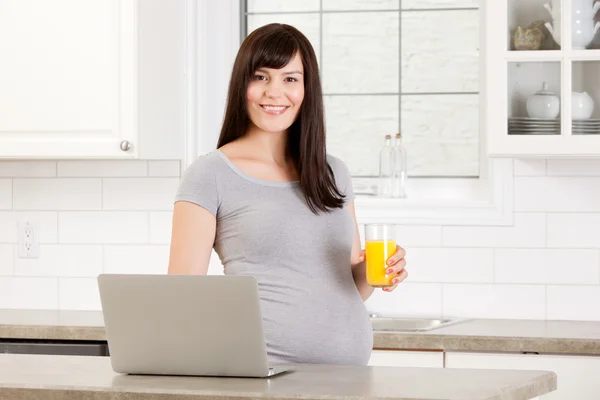 Gravid kvinna med bärbar dator — Stockfoto