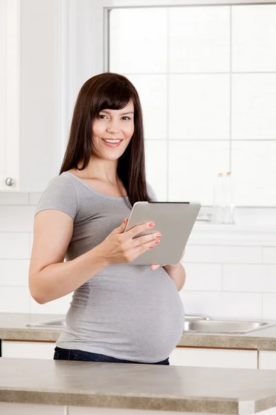 Gravid kvinna med digital tablet — Stockfoto