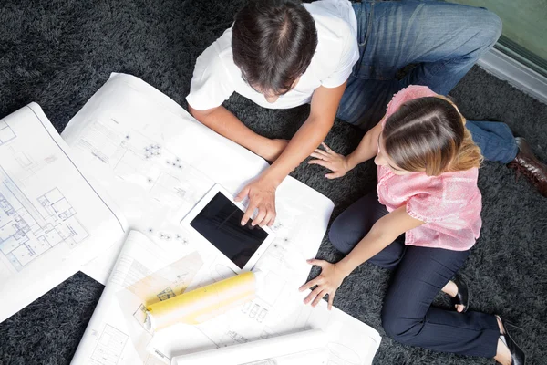 Couple Sitting On Rug With House Plans — Stock Photo, Image
