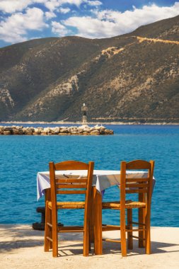 Restaurant table with a view of Vassiliki pier, Lefkada clipart