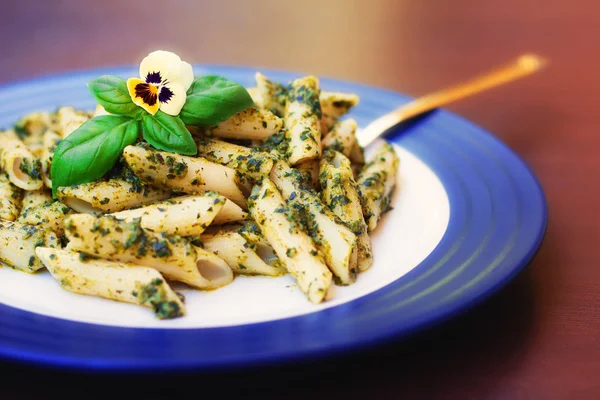 Pasta met pestosaus versierd met een eetbare bloem — Stockfoto