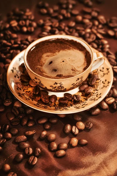 Warme kop koffie omgeven met koffiebonen — Stockfoto