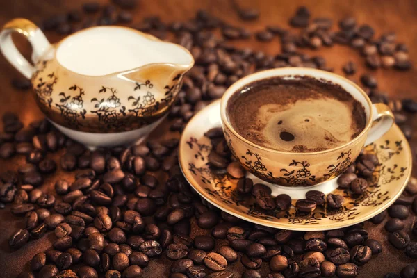 Horký šálek kávy uprostřed zrnkové kávy — Stock fotografie