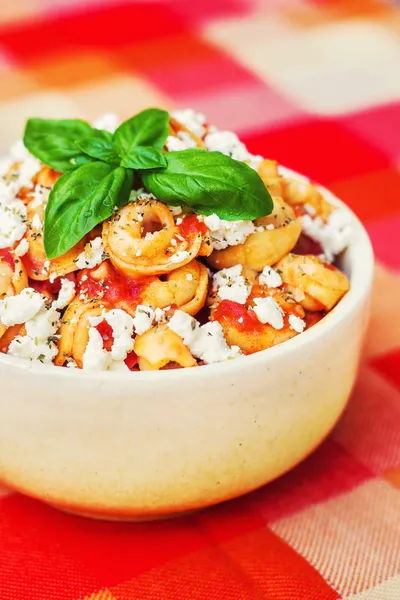 Tortellini met tomatensaus, versierd met basilicum — Stockfoto