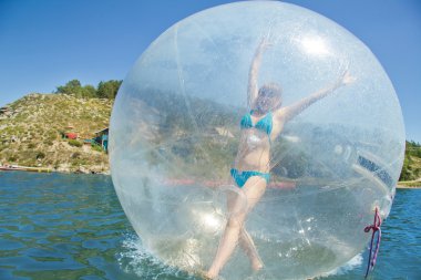 Joyful girl in a balloon floating on water. clipart