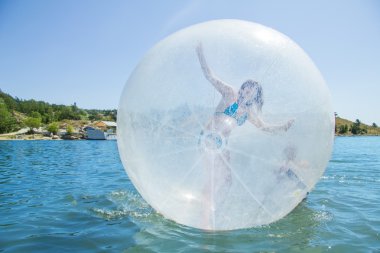 Joyful girl in a balloon floating on water. clipart