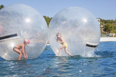 Joyful children in a balloon floating on water. clipart