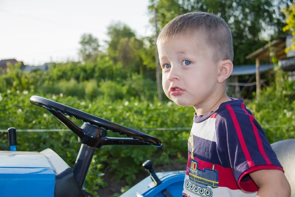 The boy drives a small tractor — Stock Photo, Image