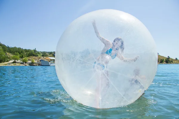 Glad flicka i en ballong flyter på vatten. — Stockfoto