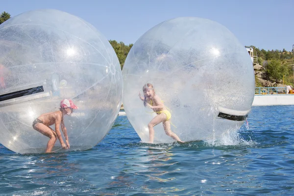 水上に浮かぶ風船の中の楽しい子供たち. — ストック写真