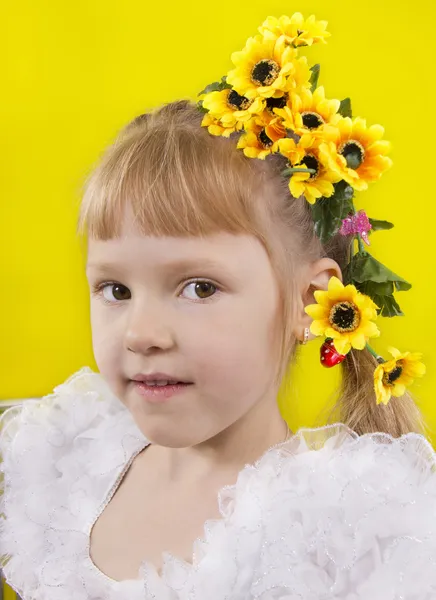 Das kleine Mädchen mit den gelben Blumen im Haar. — Stockfoto