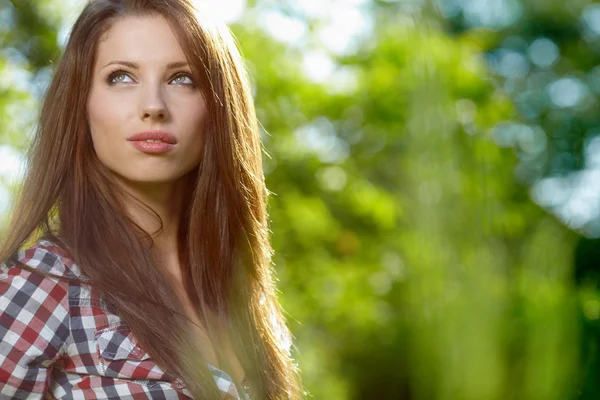 Vacker ung brunett kvinna står nära trädgård — Stockfoto