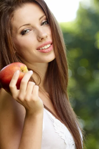 Donna con mela in giardino — Foto Stock