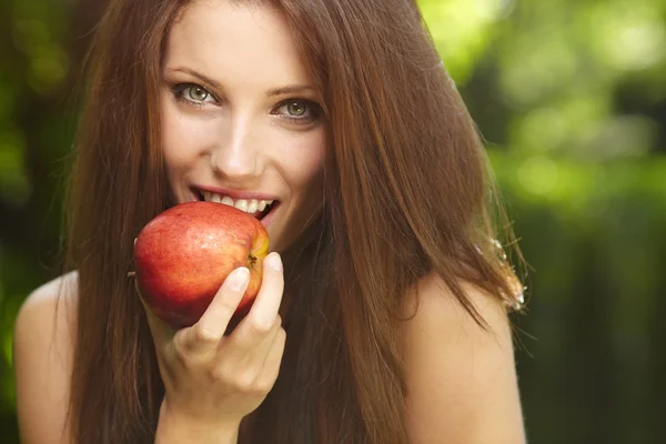 Женщина с яблоком в саду — стоковое фото