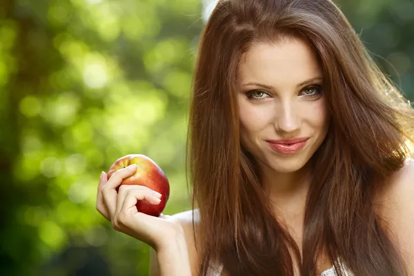 Frau mit Apfel im Garten — Stockfoto