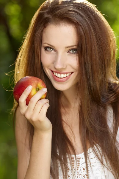 Kobieta z apple w ogrodzie — Zdjęcie stockowe