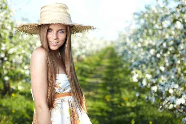Beautiful young woman standing near the apple tree on a warm sum — Stock Photo, Image