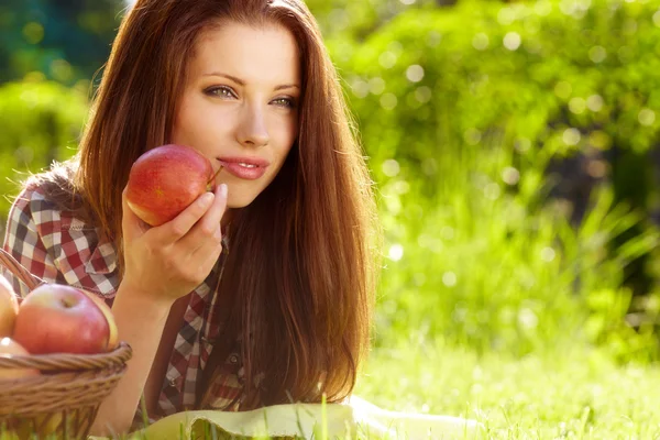 Gyönyörű nő a kertben, almával — Stock Fotó