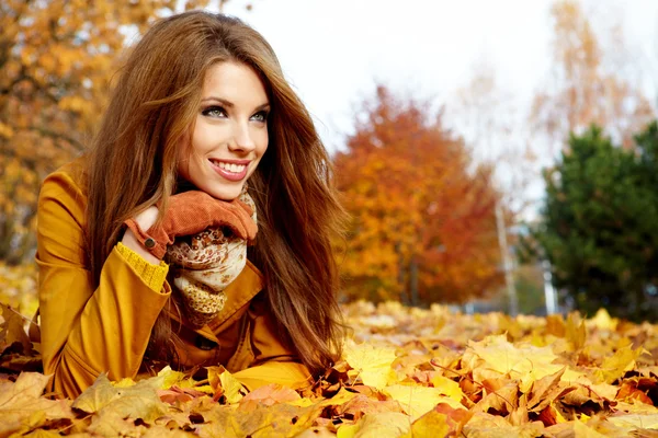 Όμορφη κομψή γυναίκα στέκεται σε ένα πάρκο το φθινόπωρο — Φωτογραφία Αρχείου