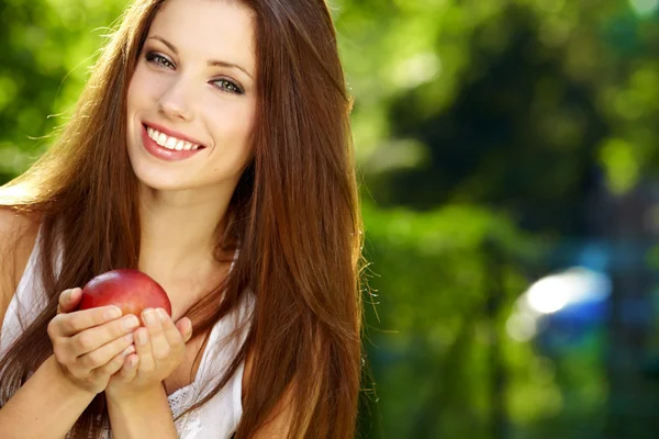 Uzun saçlı kadın portre Kırmızı elma arka plan yaz p eller. — Stok fotoğraf