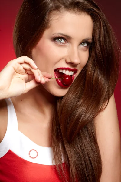 Mujer feliz con cerezas sobre rojo — Foto de Stock