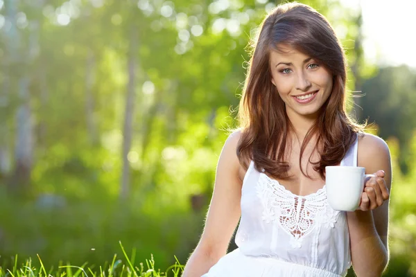 stock image Young woman at home terrace sipping tea from a cup