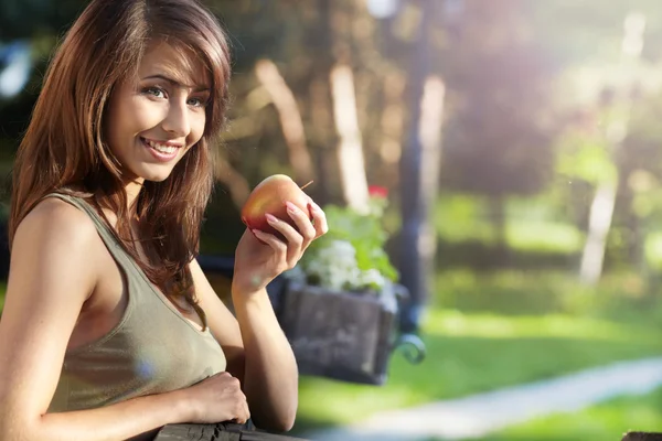 Bir adam üzerinde kırmızı elma ile güzel bir genç kız portresi — Stok fotoğraf