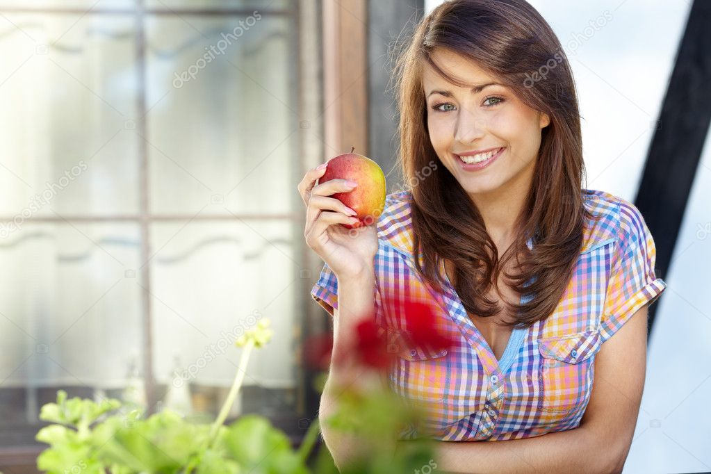 Portrait of a young beautiful girl with red apple on a backgroun