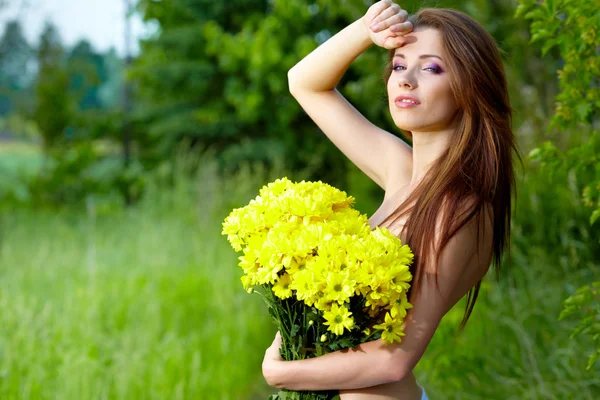 Mulher segurando flores amarelas. tiro ao ar livre — Fotografia de Stock